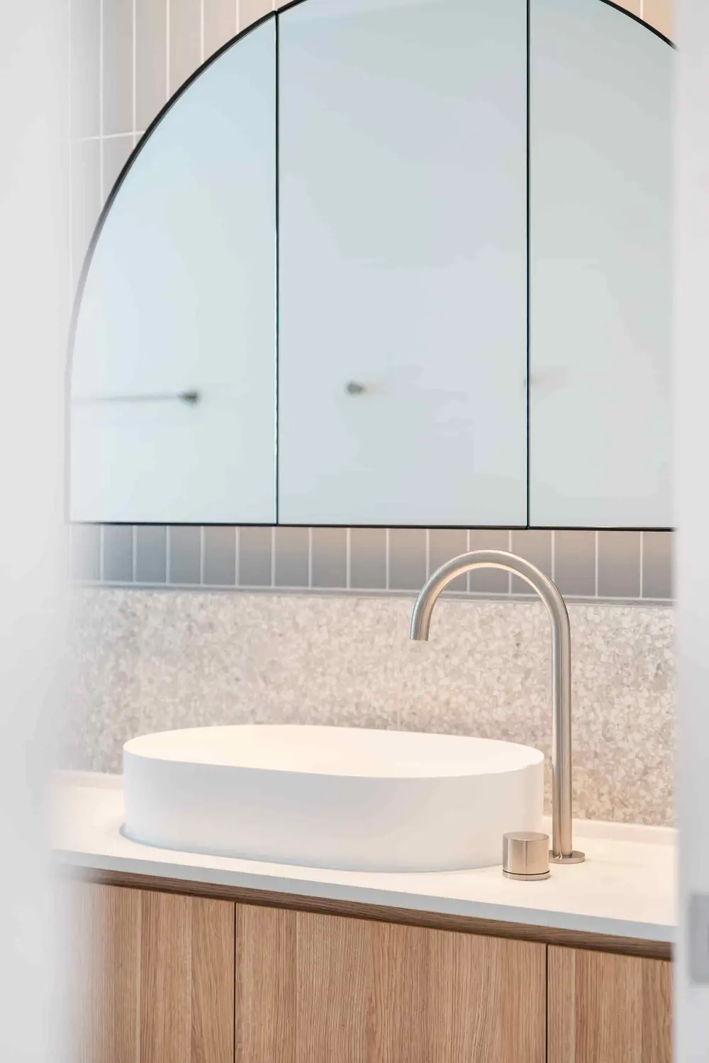 Sculptural stone basin with brushed brass tapware
